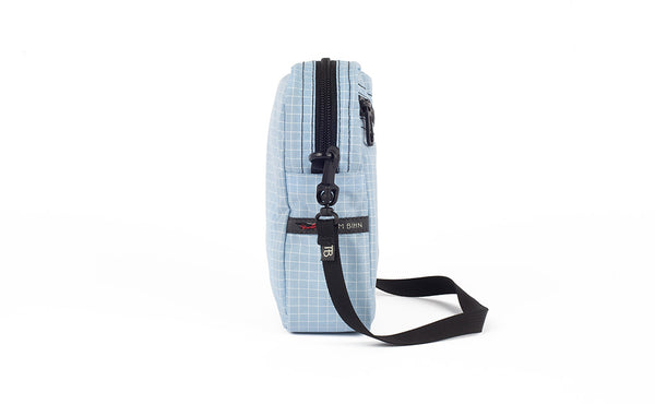 A side view of the Everyday Cubelet in Acuity Halcyon (light blue with a white grid) showing the o-ring attachment point and included 5/8" strap.